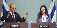 Mann und Frau vor Israel-Fahnen an Redepulten