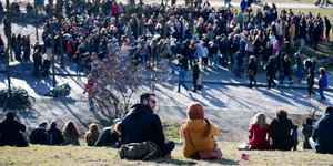 Das Foto zeigt eine Menschenmenge, die im Mauerpark in Berlin-Mitte Straßenmusikern lauscht.