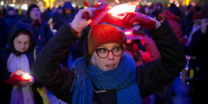 Eine Frau hält bei einem Protest gegen die Regierung ein rotes Stück Papier, um die rot-gelb-blaue Flagge Rumäniens nachzustellen