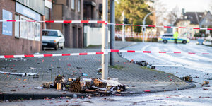 Absperrband der Polizei in Bottrop - Auf dem Boden liegen verbrannte Feuerwerkskörper
