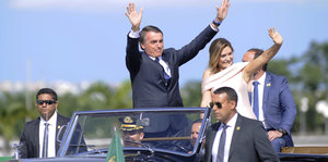 Brasiliens Präsident Jair Bolsonaro winkt, während er mit seiner Ehefrau Michelle in einem offenen Rolls Royce durch die Hauptstadt Brasilia fährt