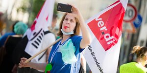 Mit Transparenten zieht streikendes Pflegepersonal der Charité durch Berlin
