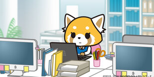 Der Panda Aggretsuko sitzt an seinem Schreibtisch.