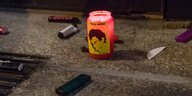 Feuerzeuge neben einer Kerze, auf der Oury Jarohs Gesicht zu sehen ist