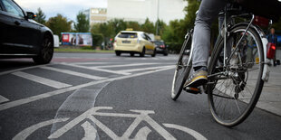 Autos und ein Radler an einem Kreisverkehr