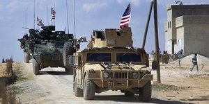 drei Militärfahrzeuge mit US-Fahnen