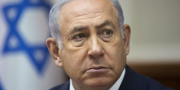 Porträt von Netanjahu vor der israelischen Flagge