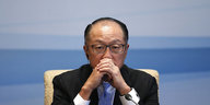 Vor einem hellblauen Hintergrund hält Weltbankchef Kim die verschränkten Hände vor den Mund