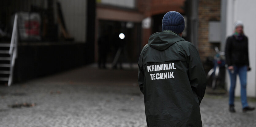 Ein Mensch steht vor einer Einfahrt. Auf der Jacke steht "Kriminaltechnik"