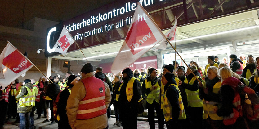 Streikendes Sicherheitspersonal steht vor der Sicherheitskontrolle