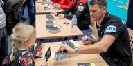 Handball-Bundestrainer Christian Prokop gibt einem jungen Mädchen ein Autogramm
