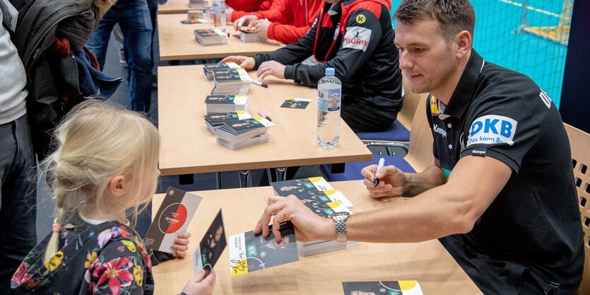 Handball-Bundestrainer Christian Prokop gibt einem jungen Mädchen ein Autogramm