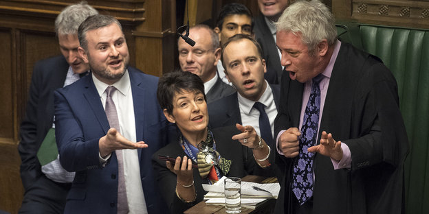 John Bercow (rechts) diskutiert offensichtlich lebhaft mit um ihn herumstehenden Parlamentariern im Unterhaus