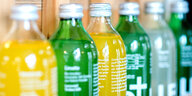 Mehrere grüne und gelb gefüllte Flaschen nebeneinander