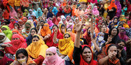 Zahlreiche bunt bekleidete Frauen protestieren