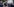 Ein junger Mann in T-Shirt und Handschellen wird von Polizisten begleitet