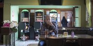 Ein Mann sitzt vor einem Getränk in einem Restaurant und zieht an einer Zigarette