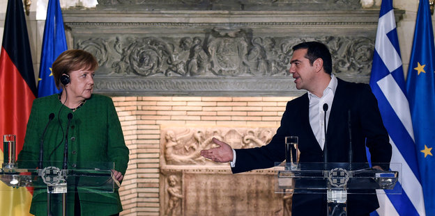 Griechenlands Premier Tsipras wendet sich bei einer Pressekonferenz an Angela Merkel und gestikuliert mit der rechten Hand