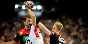 Ein südkoreanischer Handball wird von zwei deutschen am Wurf gehindert