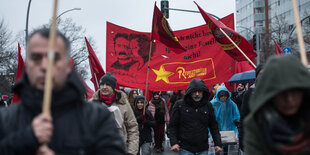 Menschen und Fahnen und Transparente auf dem Gedenkmarsch für Karl Liebknecht und Rosa Luxemburg