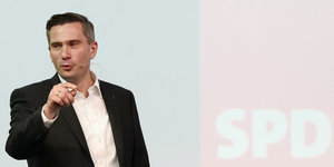 Der SPD-Politiker Martin Dulig steht auf einem Podium und reden, hinter ihm die Aufschrift "SPD"