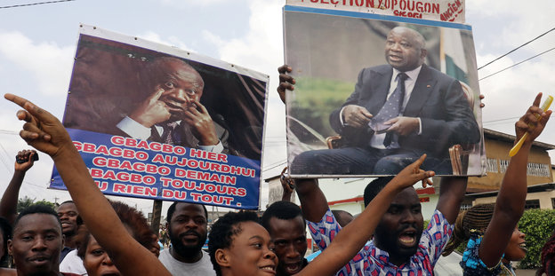 Demonstranten halten Plakate des früheren ivorischen Präsidenten Gbagbo hoch