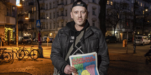 Verkäufer Ronny hält die neueste Ausgabe der Obdachlosenzeitung Karuna in den Händen