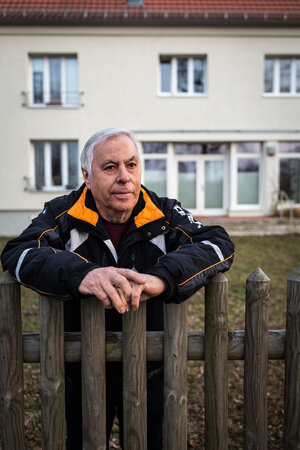 Ein Mann lehnt an einem Gartenzaun Ein Mann lehnt an einem Gartenzaun