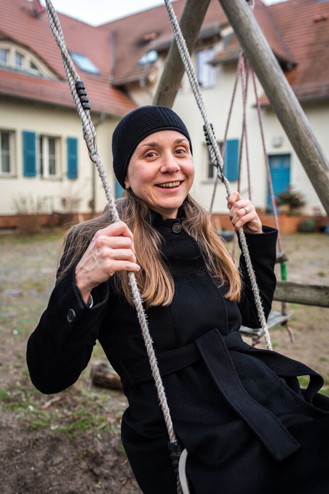 Eine Frau sitzt auf einer Schaukel