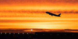 ein Flugzeug vor einem gelb-roten Himmel