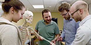 Studierende stehen vor einem künstlichen Skelett im Trainingszen­trum der Universität Göttingen.