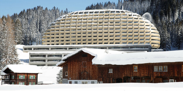 Ein futuristisch runder Hotelbau im Schnee