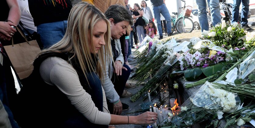 Menschen legen zum Gedenken Blumen nieder