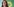 Eine Frau mit langen Haaren und Brille vor dem Logo der Grünen