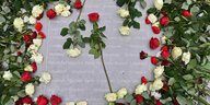 Rote und weiße Rosen liegen nach einer Kranzniederlegung im früheren NS-Konzentrationslager Buchenwald auf einer Gedenkplatte