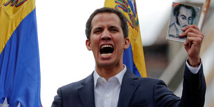 Guaidó hält schreiend die venezolanische Flagge