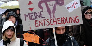 Frauen protestieren mit einem Schild