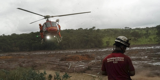 Ein Hubschrauber landet auf einem Gelände. Die Einsatzkräfte konnten 46 Menschen aus dem Schlamm retten, aber noch immer rund 300 Menschen werden vermisst.