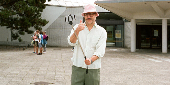 Daniel Haaksmann macht ein Selfie mit einem Selfiestick