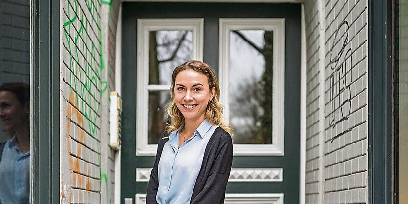 Nora Blum steht vor einem Hauseingang.