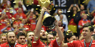 Handballer Hansen reckt goldene Trophäe in die Höhe