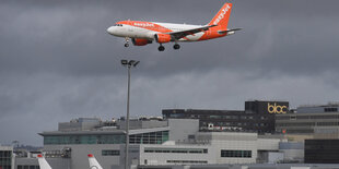 Flugzeug im Landeanflug vor düsterem Himmel