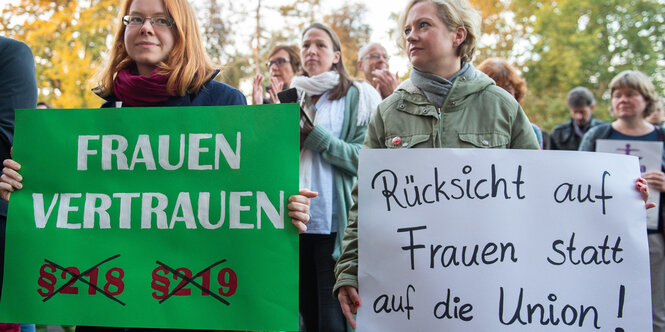 Frauen halten bei einer Kundgebung Plakate mit der Aufschrift «Frauen Vertrauen» und «Rücksicht auf Frauen statt auf die Union!"