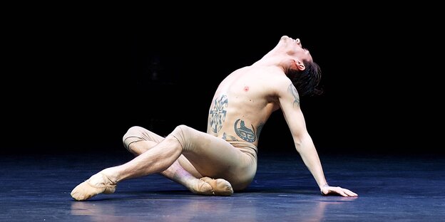 Sergei Polunin tanzt mit freiem Oberkörper, er hat ein Kolovrat-Symbol auf den Bauch tatoowiert