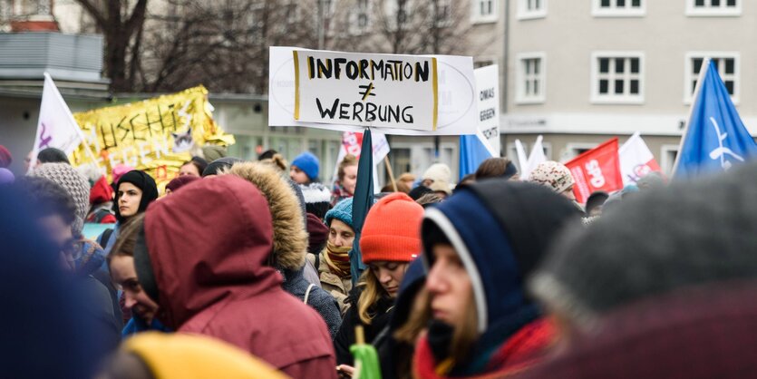 Ein Schild auf einer Demonstration, auf ihm steht: Informationen sind nicht gleich Werbung