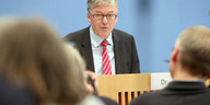 Hans-Peter Bartels vor der blauen Wand der Bundespressekonferenz