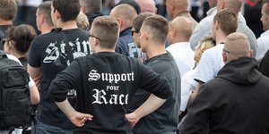 Rechtsextreme bei einem Aufmarsch in Spandau, im Fokus ist ein Mann, der einen Pullover mit der Aufschrift "Support your Race" trägt
