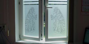 Ein Fenster mit darauf abgebildeten Lungenflügeln