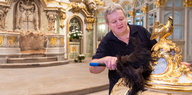 Ein Mann putzt in der Dresdner Frauenkirche den Golddeckel eines Taufbeckens. Was und ob er glaubt, ist nicht zu erkennen