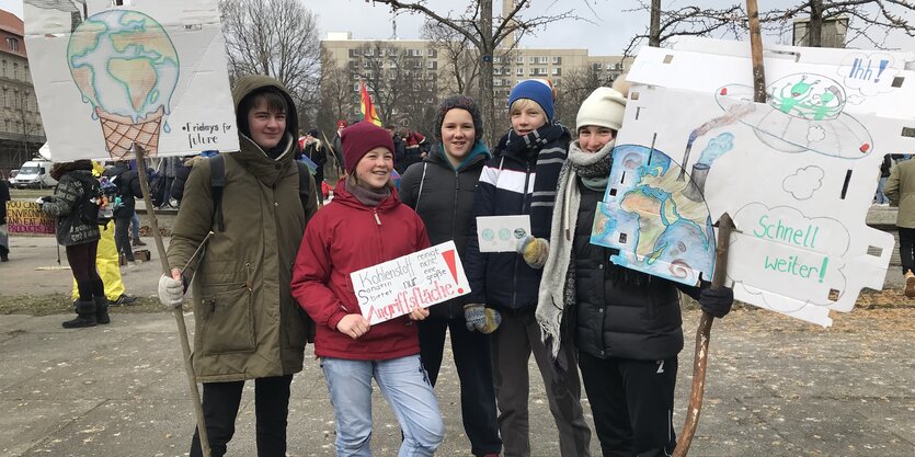 Fünf junge Frauen mit Prostestplakaten gegen die Kohlenutung stehen in eienr Gruppe zusammen